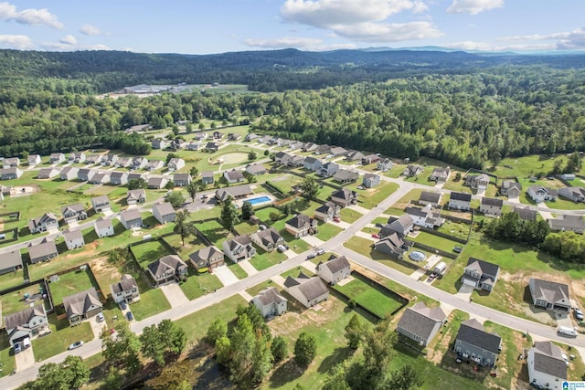 view of property location with a heavily wooded area and nearby suburban area