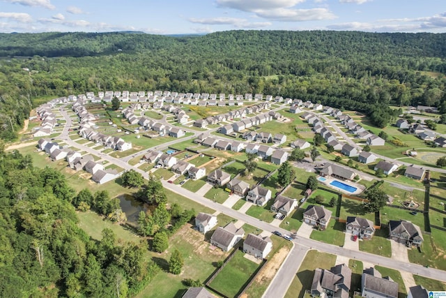 aerial view of property's location with a forest and nearby suburban area