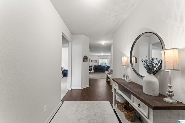 hallway with wood finished floors and baseboards