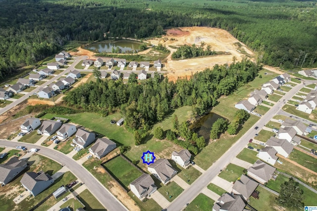 aerial view of property's location with a forest, a large body of water, and nearby suburban area