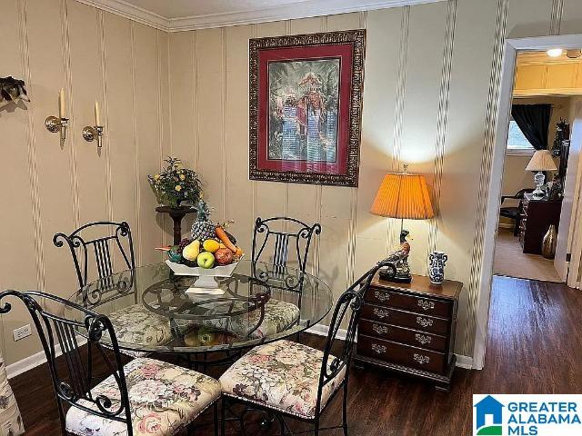 dining space featuring crown molding and dark hardwood / wood-style flooring