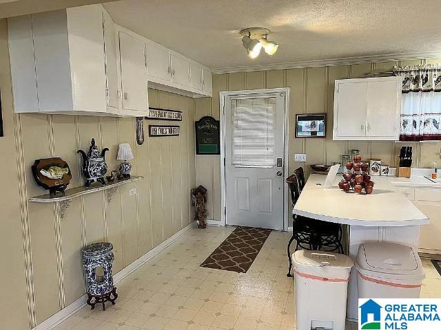 kitchen with white cabinets and a textured ceiling