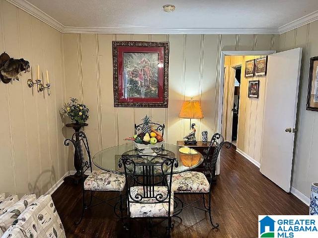 dining space featuring ornamental molding and dark wood-type flooring