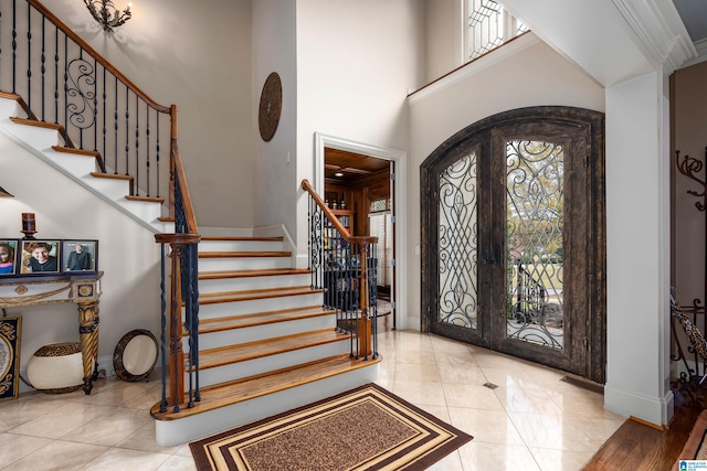 tiled entrance foyer featuring french doors and a high ceiling