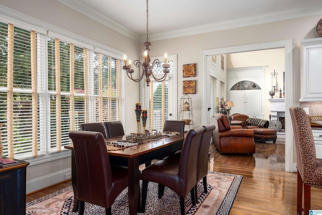 dining area with ornamental molding, light hardwood / wood-style flooring, and an inviting chandelier