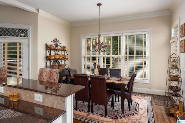 dining space featuring ornamental molding, hardwood / wood-style floors, a notable chandelier, and a healthy amount of sunlight