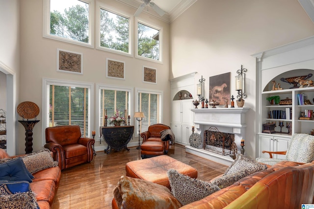 living room featuring hardwood / wood-style flooring, ornamental molding, and a high ceiling