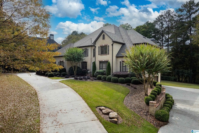 french provincial home featuring a front yard