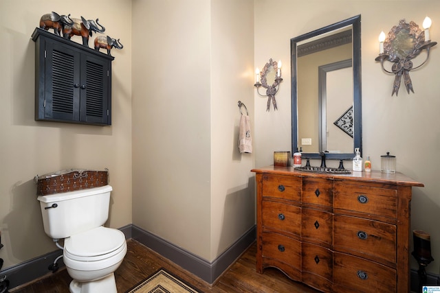 bathroom with vanity, toilet, and hardwood / wood-style floors