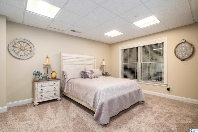 carpeted bedroom featuring a drop ceiling