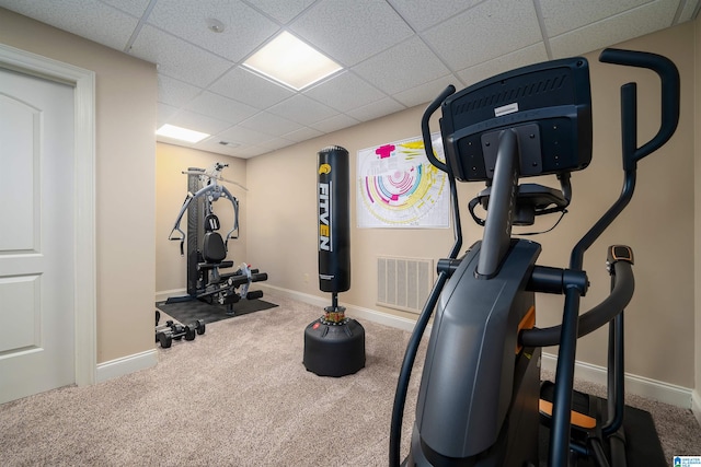 exercise room featuring carpet and a paneled ceiling