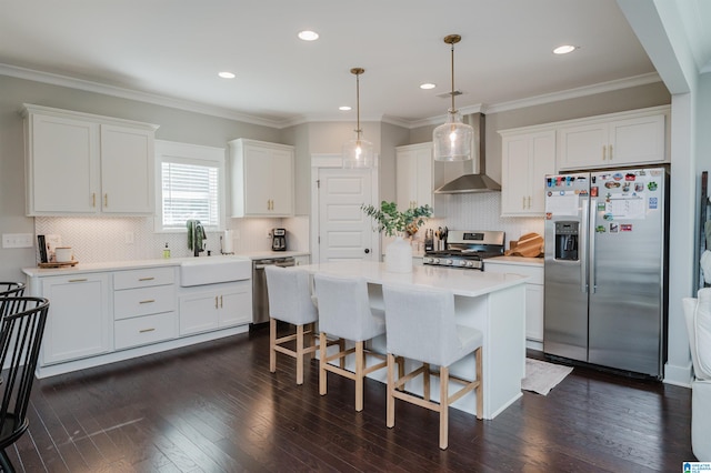 kitchen featuring stainless steel appliances, wall chimney range hood, dark wood-type flooring, and white cabinetry