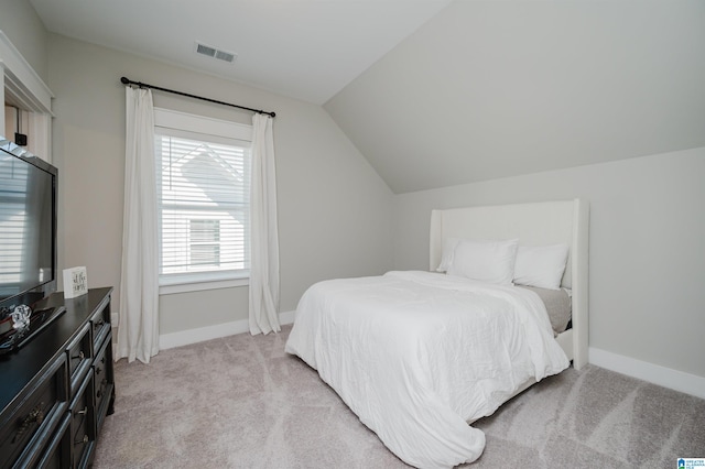 bedroom with light carpet and vaulted ceiling