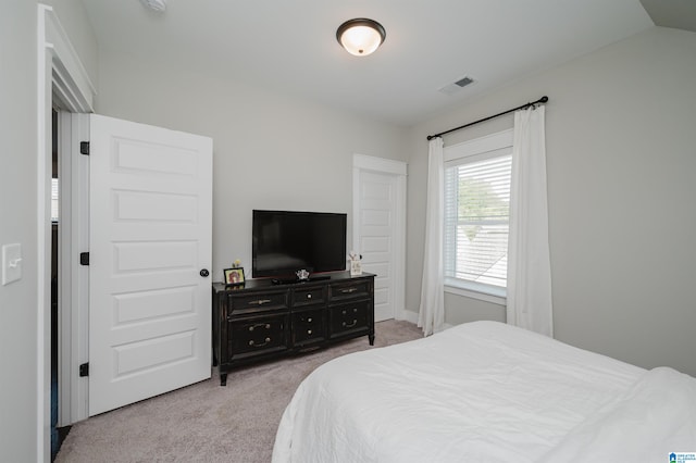 bedroom featuring light colored carpet and lofted ceiling