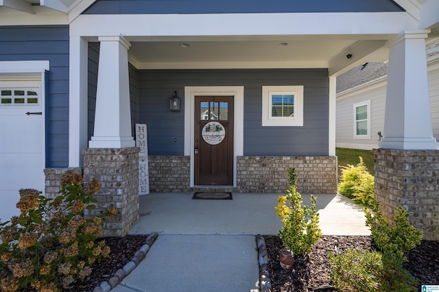 doorway to property featuring covered porch and a garage