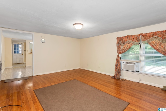 unfurnished room with hardwood / wood-style flooring and a textured ceiling