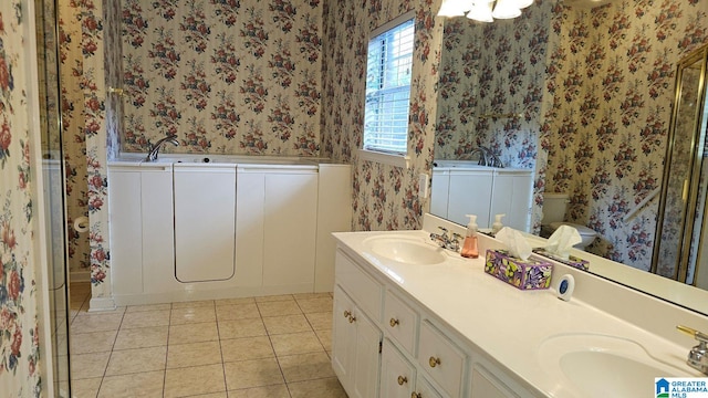 bathroom featuring tile patterned flooring, a tub to relax in, vanity, and toilet