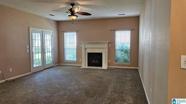 unfurnished living room featuring french doors, a textured ceiling, dark colored carpet, and ceiling fan