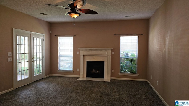 unfurnished living room featuring dark colored carpet, ceiling fan, french doors, and a textured ceiling