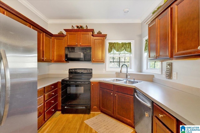 kitchen with ornamental molding, light wood-type flooring, sink, and black appliances