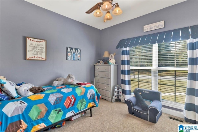 carpeted bedroom with ceiling fan and multiple windows