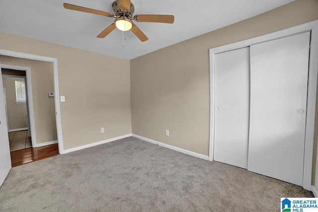 unfurnished bedroom with a closet, light colored carpet, and ceiling fan