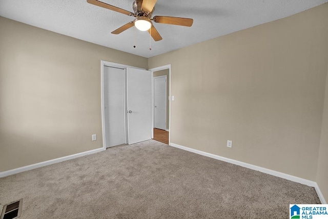 unfurnished bedroom with a closet, carpet, a textured ceiling, and ceiling fan