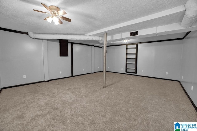 basement with light carpet, a textured ceiling, and ceiling fan