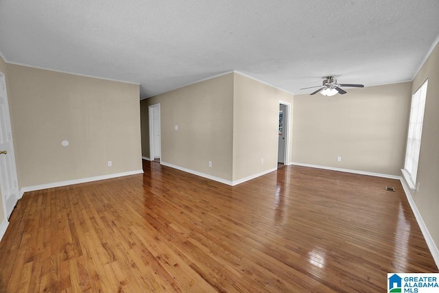 unfurnished room featuring ceiling fan, hardwood / wood-style flooring, crown molding, and a textured ceiling