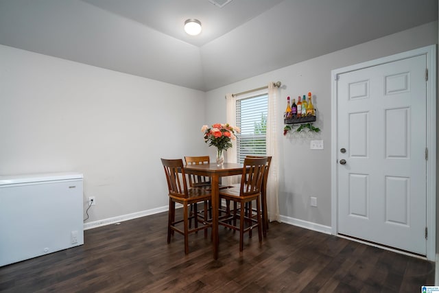 dining room with dark hardwood / wood-style flooring and lofted ceiling