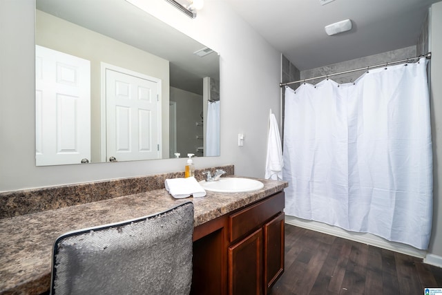 bathroom featuring hardwood / wood-style floors, vanity, and shower / bath combo