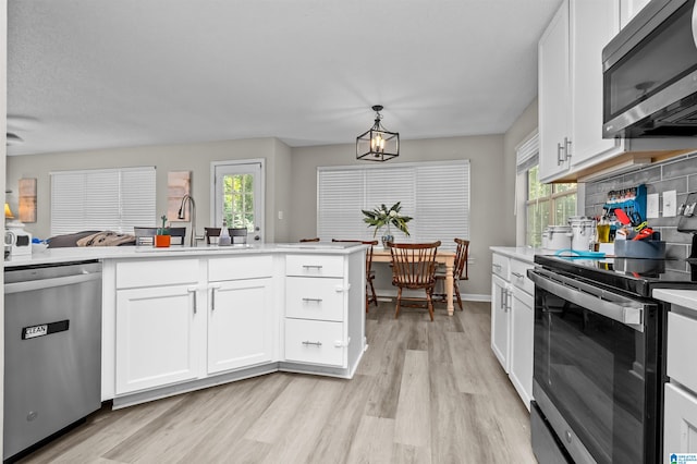 kitchen featuring stainless steel appliances, sink, a wealth of natural light, and white cabinetry