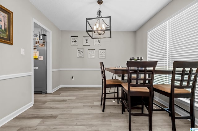 dining space with light hardwood / wood-style floors and a chandelier