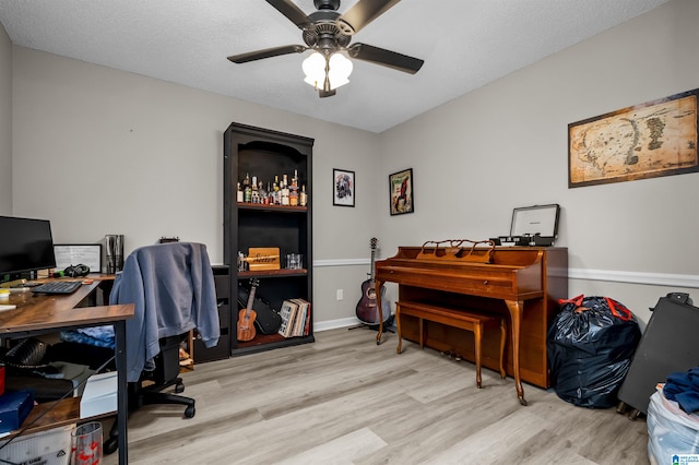 office area with ceiling fan, a textured ceiling, and light hardwood / wood-style floors