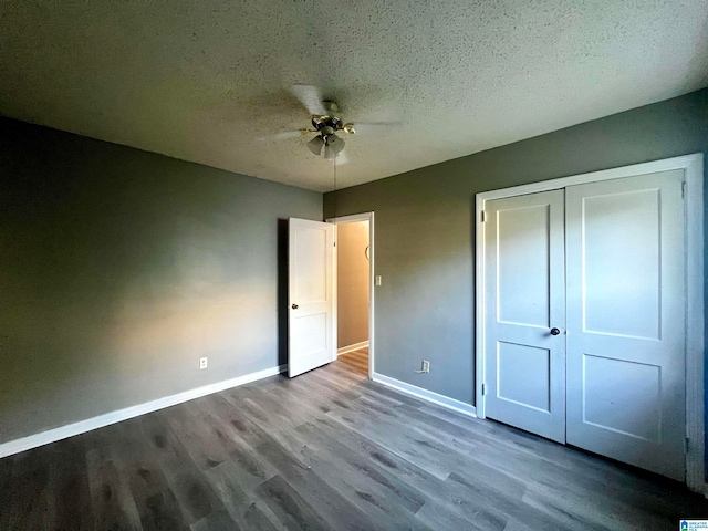 unfurnished bedroom with wood-type flooring, a textured ceiling, a closet, and ceiling fan