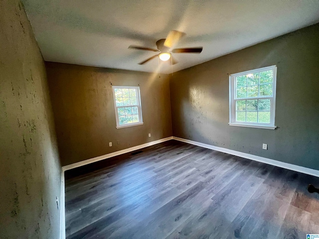 empty room featuring ceiling fan, a textured ceiling, and dark hardwood / wood-style flooring