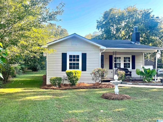 ranch-style home featuring a front lawn and covered porch