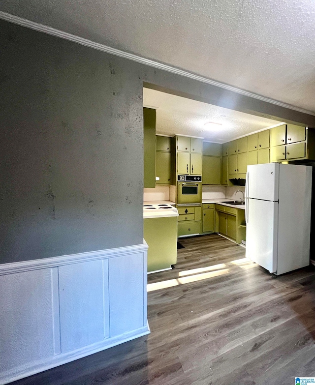 kitchen with white refrigerator, wall oven, light wood-type flooring, sink, and a textured ceiling