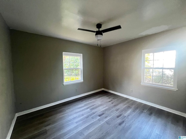 spare room featuring ceiling fan, a wealth of natural light, and dark hardwood / wood-style floors