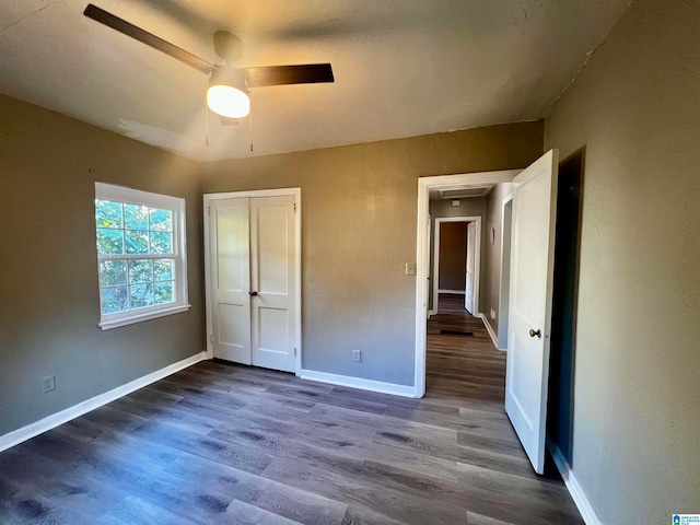 unfurnished bedroom featuring wood-type flooring, a closet, and ceiling fan