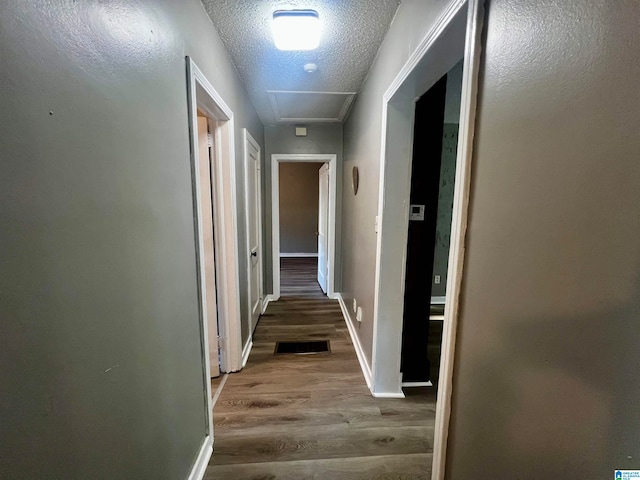 hall featuring dark hardwood / wood-style floors and a textured ceiling