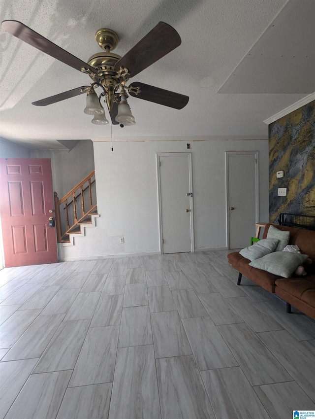 unfurnished living room featuring ceiling fan, a textured ceiling, and crown molding