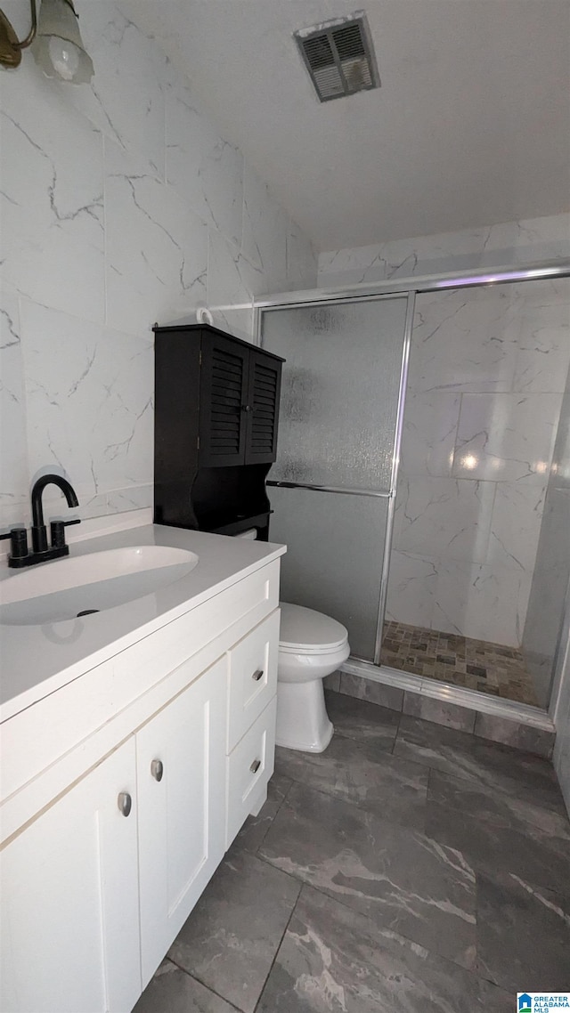 bathroom featuring toilet, a shower with door, and vanity