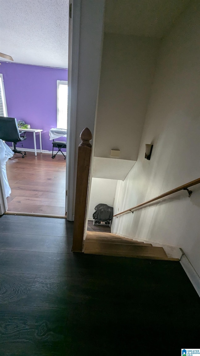 stairway with hardwood / wood-style flooring and a textured ceiling