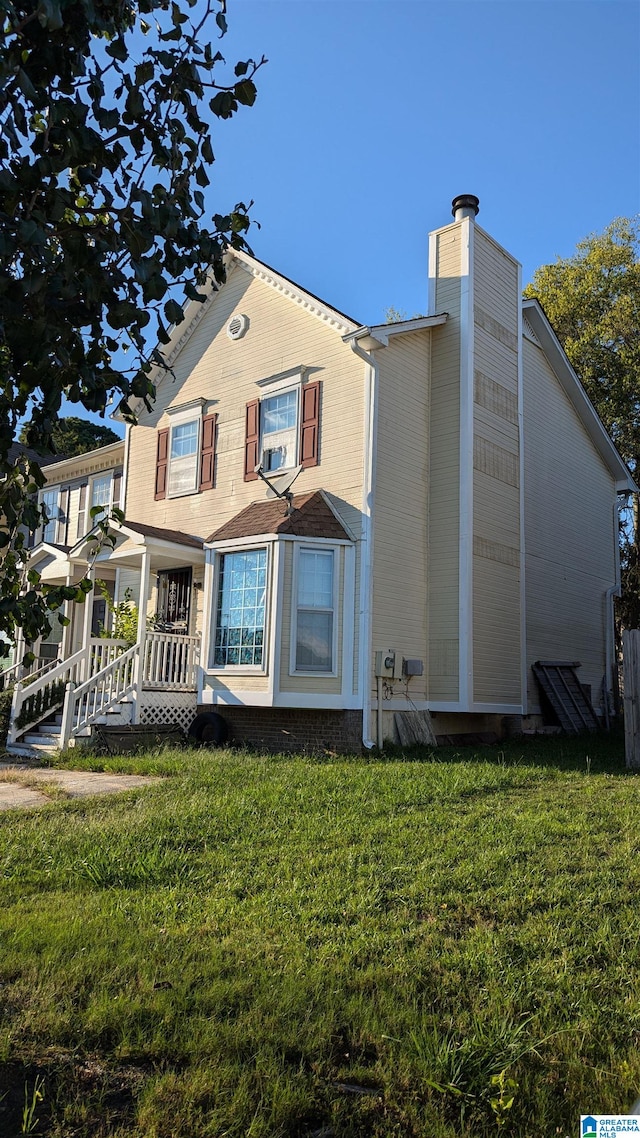 rear view of property with a yard and covered porch