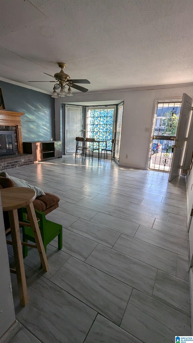 unfurnished living room with ceiling fan and a textured ceiling