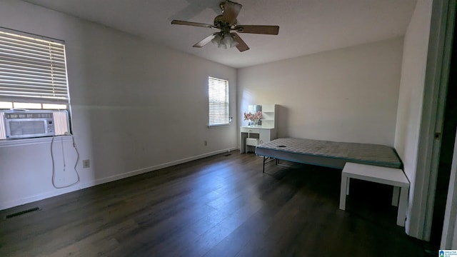 bedroom featuring ceiling fan, cooling unit, and dark hardwood / wood-style flooring