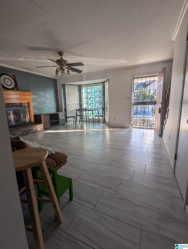 unfurnished living room with ceiling fan, a wealth of natural light, ornamental molding, and a textured ceiling