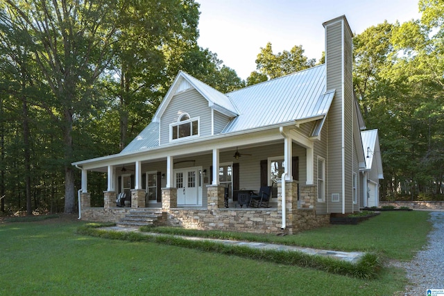 view of front facade with a garage, a porch, a front yard, and ceiling fan