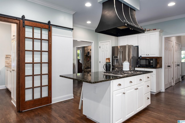 kitchen with island exhaust hood, stainless steel appliances, a barn door, white cabinets, and a center island